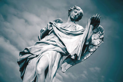 Low angle view of angel statue against sky