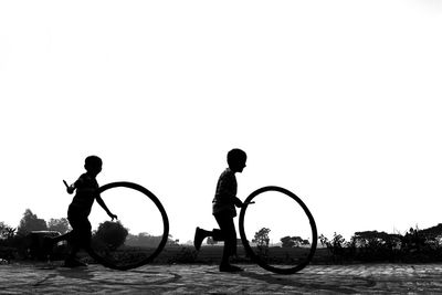 Silhouette people on boat against clear sky