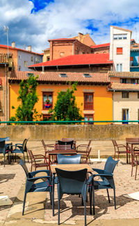 Empty chairs and tables at outdoor cafe