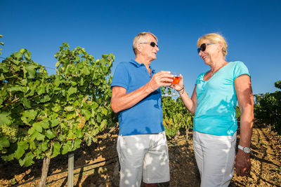 Friends on the ground against blue sky