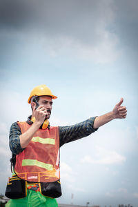 Man wearing hat standing against sky