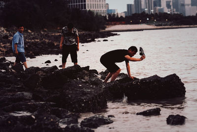 Children on rock at sea shore
