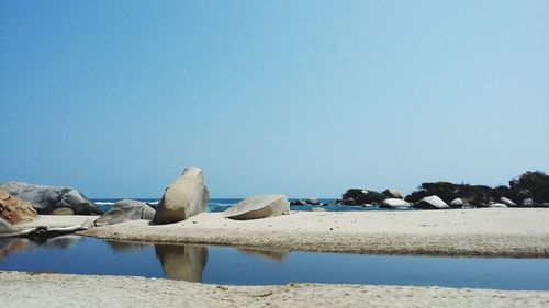 Scenic view of beach against clear blue sky