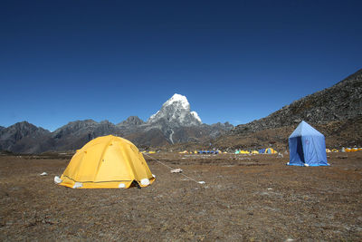 Tent in mountains against clear blue sky