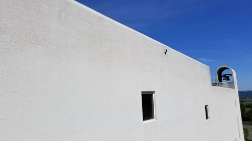 Low angle view of white building against clear blue sky