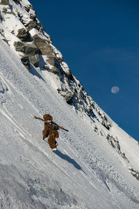 Person skiing on snowcapped mountain against sky