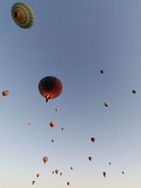 Low angle view of balloons flying against clear blue sky