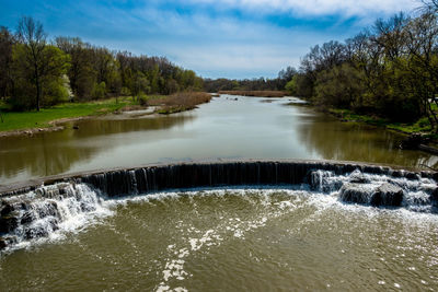 Scenic view of waterfall in forest against sky