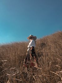 Woman standing on field against clear sky