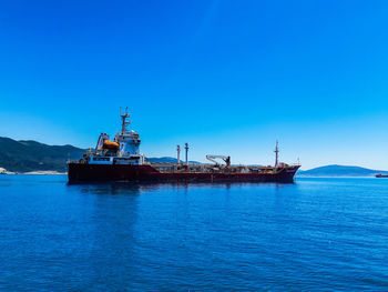 Ship in sea against clear blue sky