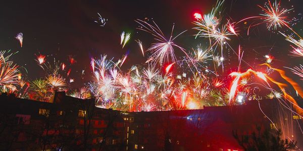 Low angle view of illuminated firework display at night