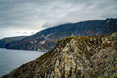 Scenic view of sea and mountains against sky