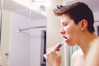 Portrait of young woman brushing teeth