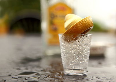 Close-up of wet tequila glass on table