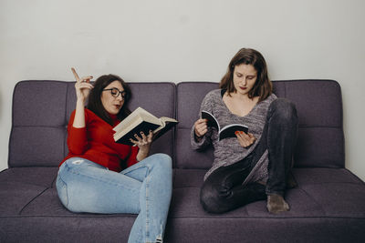 Young woman sitting on sofa at home