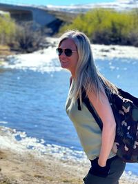 Portrait of young woman wearing sunglasses on beach