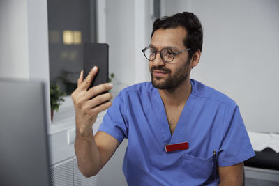 Male doctor having online consultation on smart phone