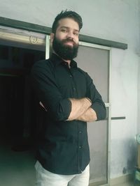 Portrait of young man standing at home