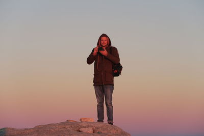 Low angle view of man photographing against sky