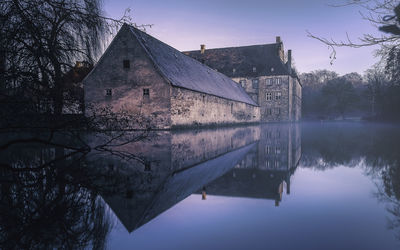 Reflection of building on lake against sky