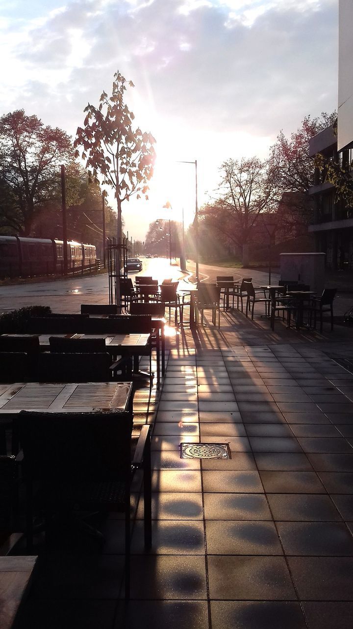 EMPTY BENCH AND TABLES AGAINST SKY