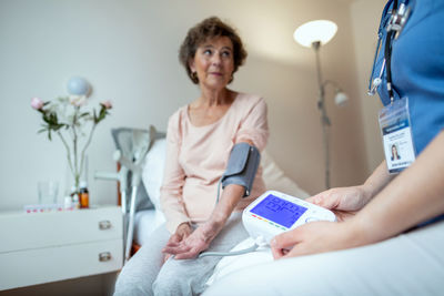 Woman using mobile phone while sitting in kitchen
