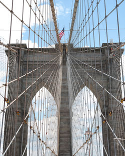 Low angle view of suspension bridge against sky