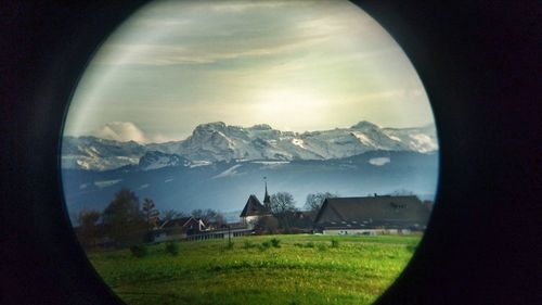 Scenic view of landscape against sky seen through window