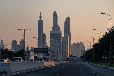 View of city street against sky during sunset