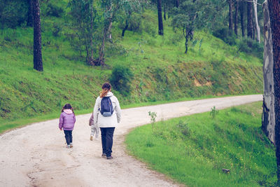 Rear view of two women walking on road