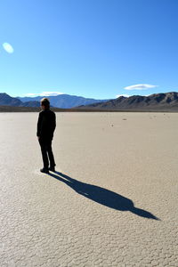 Full length of man on desert against clear sky in racetrack playa