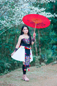 Woman holding umbrella while standing outdoors