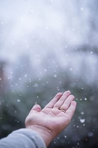 Close-up of human hand on wet glass