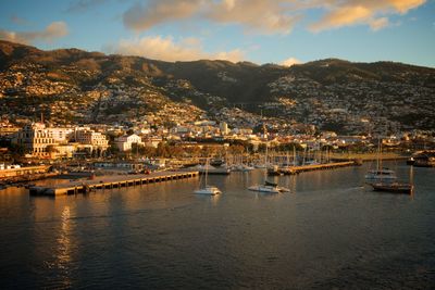 Aerial view of townscape by sea against sky