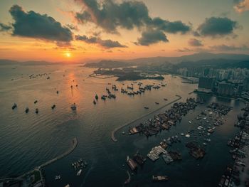 High angle view of hong kong city and bay against sky during sunset