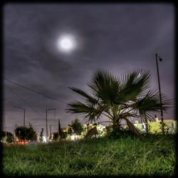 View of field against cloudy sky