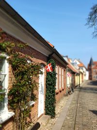 Footpath amidst buildings against sky