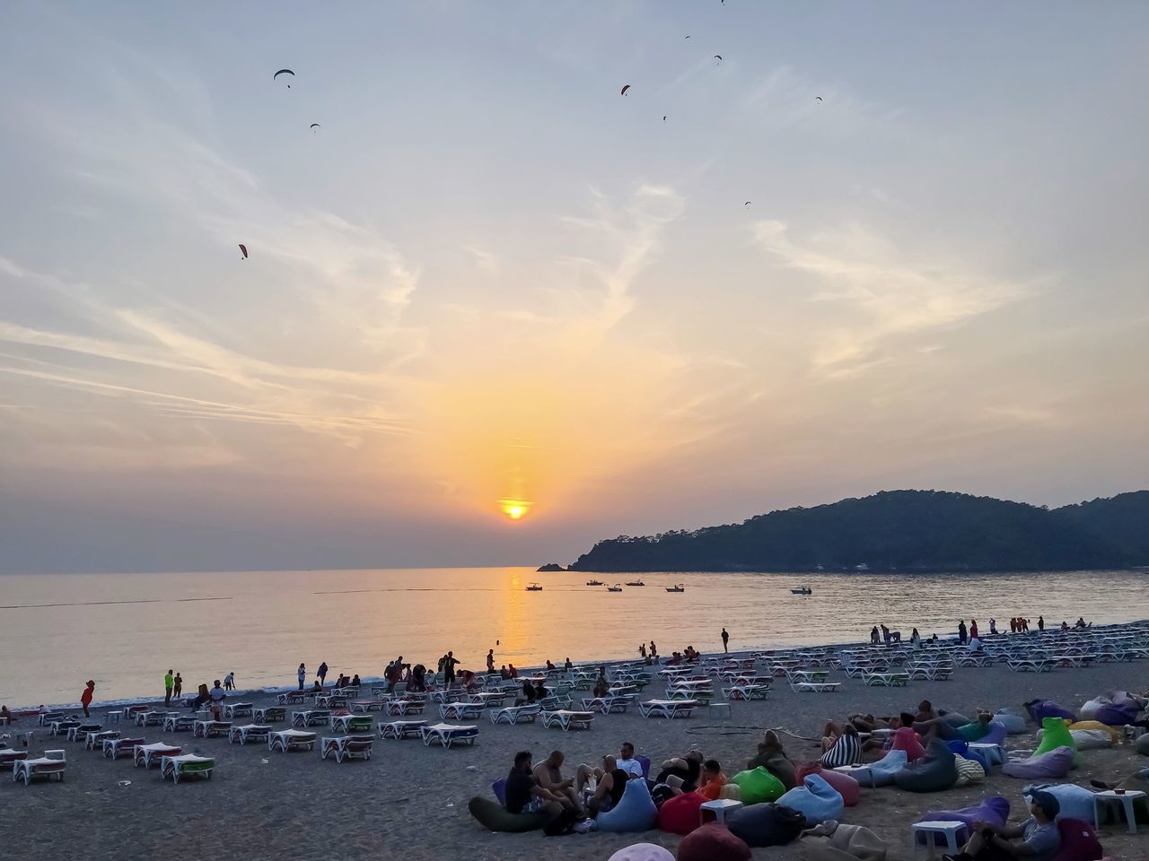 GROUP OF PEOPLE ON BEACH DURING SUNSET