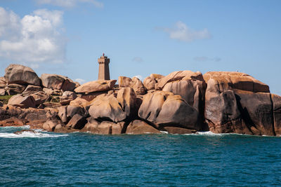 Lighthouse amongst pink granite boulders, ploumanach coast, brittany, france