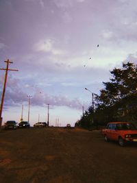 Cars on road against sky in city