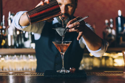 Close-up of wine pouring glasses on bar counter