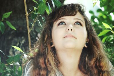 Girl looking up against plants