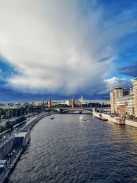 City at waterfront against cloudy sky