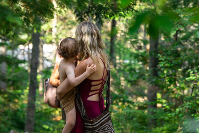 Rear view of mother and daughter on tree