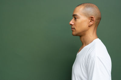 Side view of man standing against blue background
