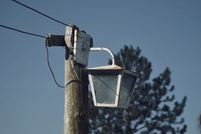 Low angle view of birdhouse against sky lighting 