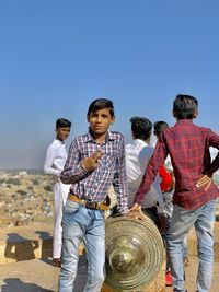 People standing against clear blue sky