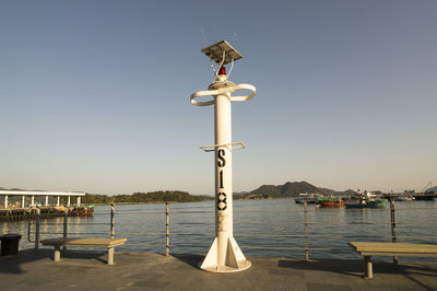 Street light by sea against clear sky