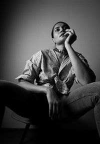 Young woman sitting on chair at home