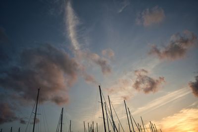 Low angle view of sailboats moored at harbor against sky